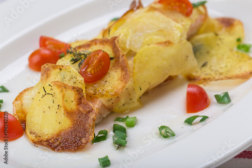 Fish in baked potatoes decorated with cherry tomatoes