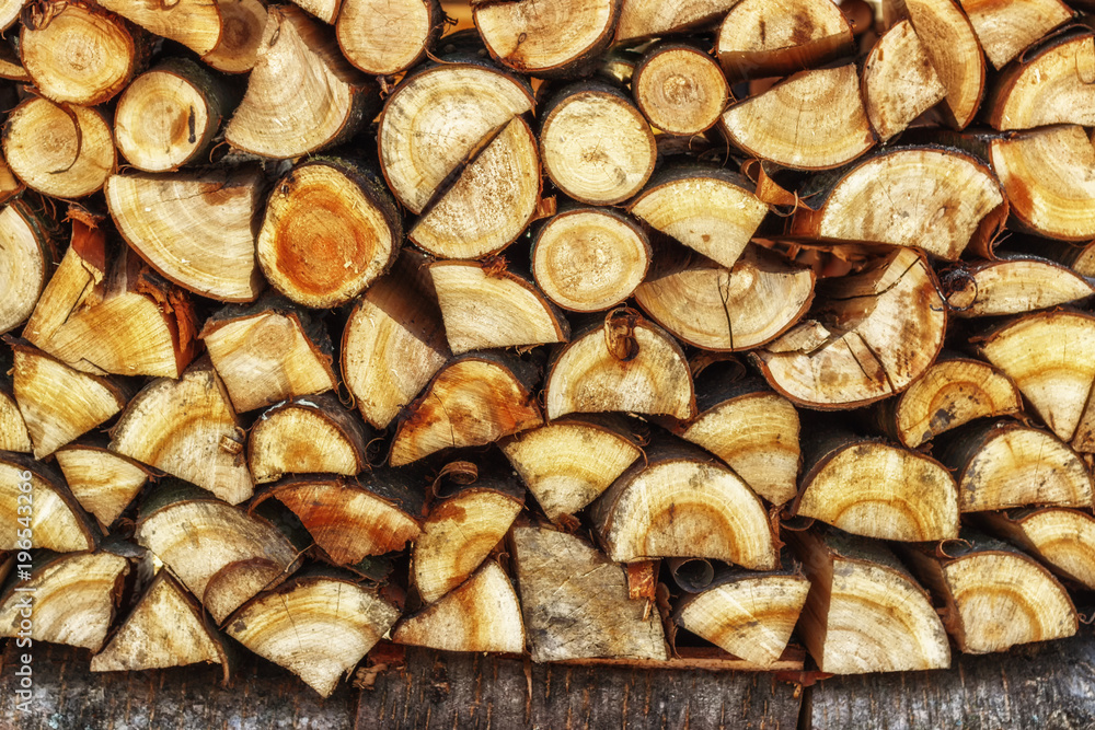 Firewood for the winter. Firewood for barbecue. A background made of wood. Cut and chopped logs with ready-made pieces of wood for heating. Ecological concept.