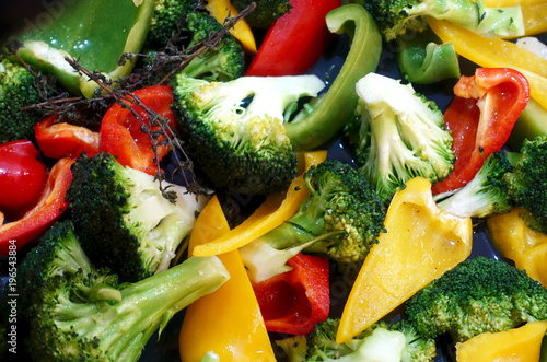 Close-up slices of vegetables as a background. Colorful fresh pepper, cauliflower and broccoli mixed.