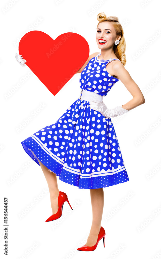 smiling woman holding heart symbol, dressed in pin-up style smiling woman holding heart symbol, dressed in pin-up style