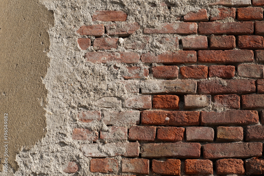 Old brick wall with patches of cement and worn plaster. Old brick wall with patches of cement and worn plaster.