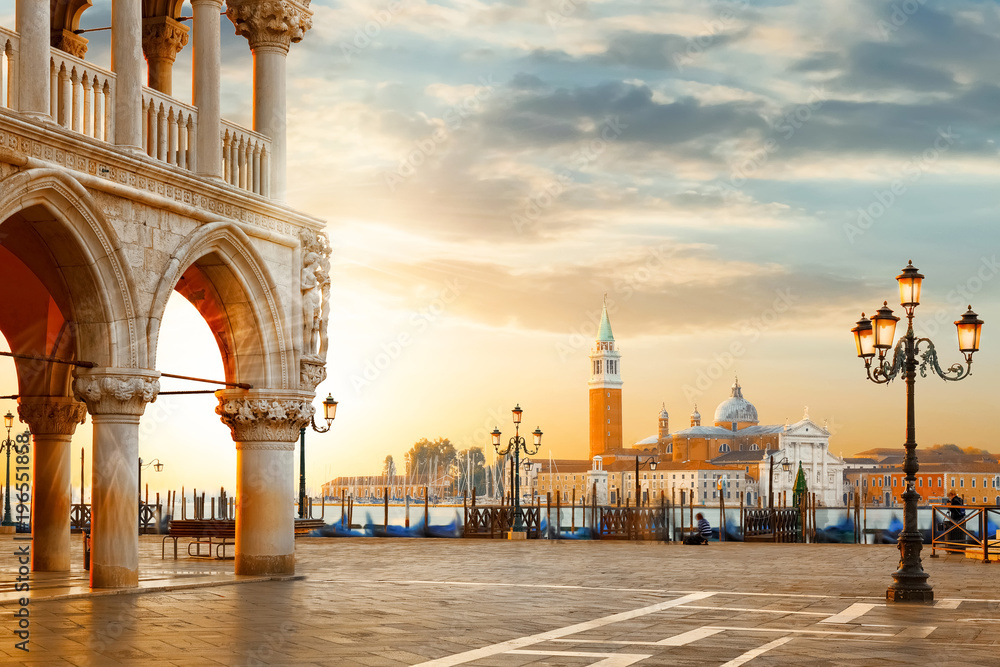 Fototapeta premium Pocztówka z Wenecji. Znane na całym świecie zabytki Wenecji. Plac Świętego Marka z kościołem San Giorgio Maggiore podczas niesamowitego wschodu słońca. Turystyka i koncepcja podróży we Włoszech.