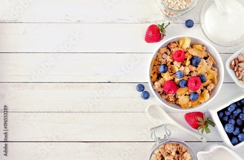 Stampa su tela Cereal and ingredients for a healthy breakfast forming a side border over a white wood background