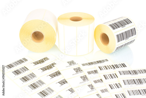 White label rolls and printed barcodes isolated on white background with shadow reflection. White reels of labels for printers. Labels for direct thermal or thermal transfer printing. Barcode samples. photo