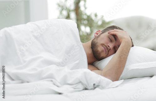 young man is sleeping in a comfortable hotel room