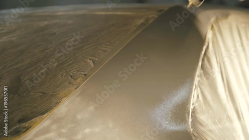 Mechanic spraying primer on a car surface. 4K photo