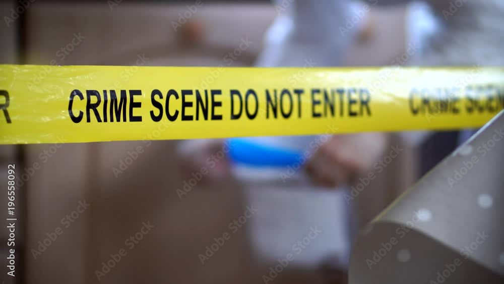 Crime Scene Police Tape With CSI Working With Evidence Bag In 