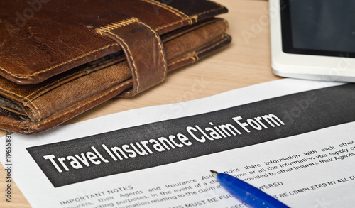 travel insurance claim form on a wooden surface photo