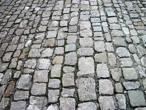 Stone pavement in perspective. Stone pavement texture. Cobblestone pavement background. Abstract background of old cobblestone pavement close-up.    
