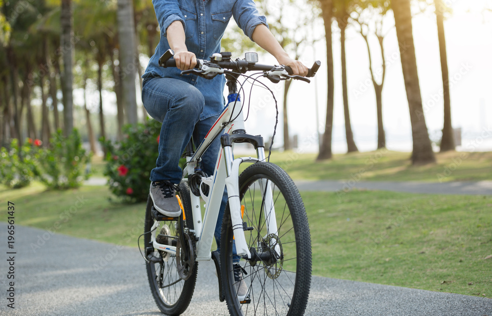 one cyclist riding bike in tropical spring park