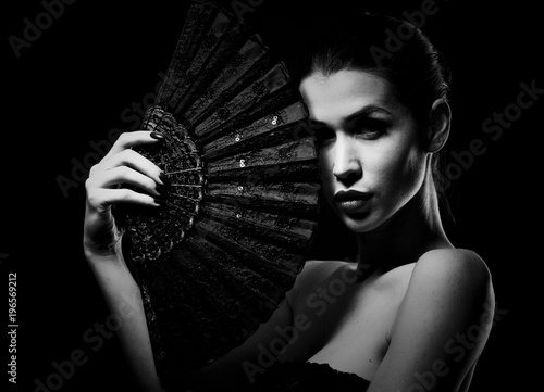 mysterious woman holding a fan black and white