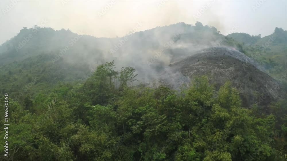 Aerial over a slash and burn mountainside burning. Aerial over a slash and burn mountainside burning.