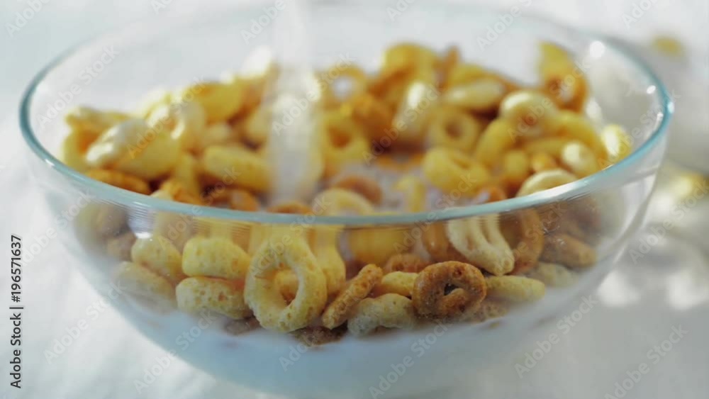 Milk is poured onto cereal in a bowl. Milk is poured onto cereal in a bowl.