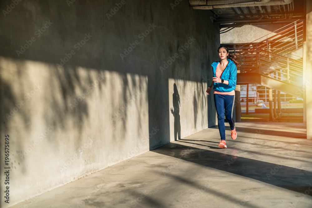 Woman running on sidewalk at sunset in the city. Woman running on sidewalk at sunset in the city.