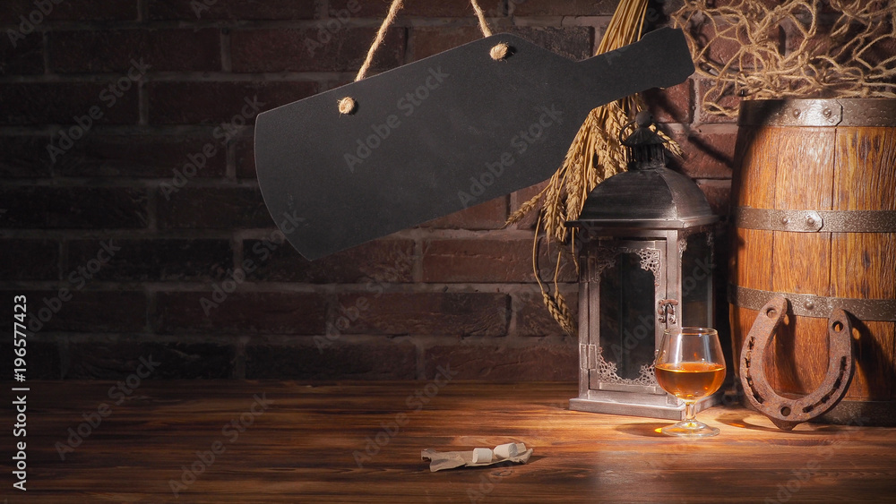 Glass of cognac with barrel on brick backgroun