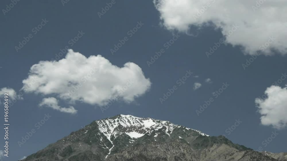Clouds pass over a mountain on a grassy plain. Clouds pass over a mountain on a grassy plain.