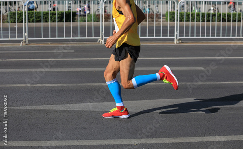 marathon runner legs running on city road