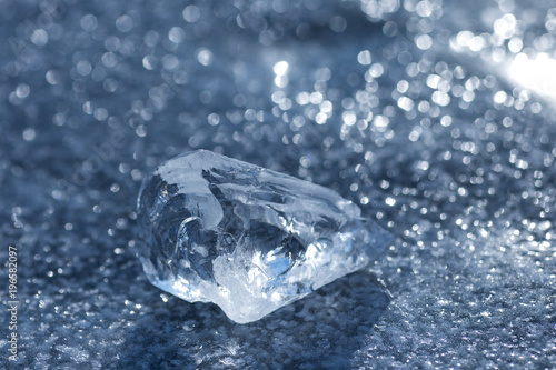 Shining piece of ice lies on lake ice.