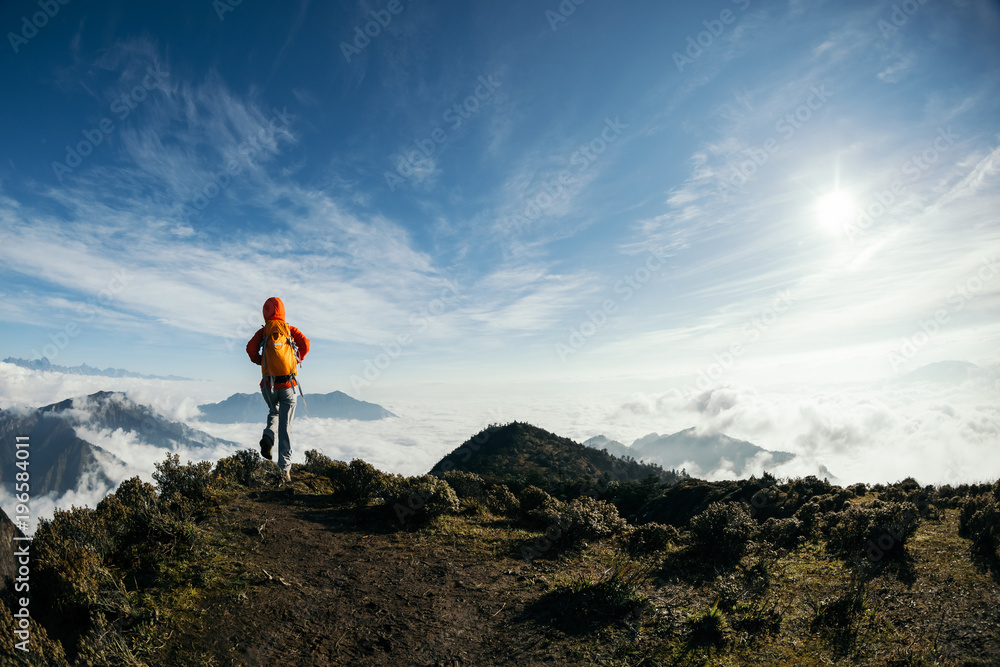 successful hiker walking in the beautiful landscape on mountain top