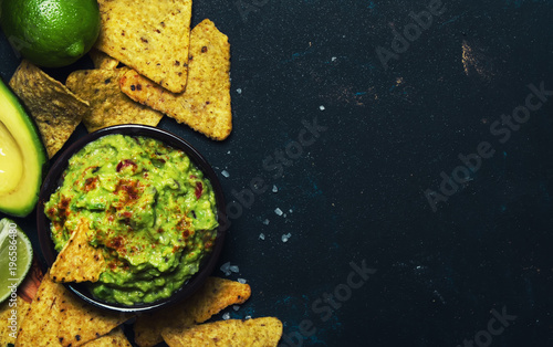Mexican food, guacamole sauce with avocado, onion, garlic and chili, black background, top view