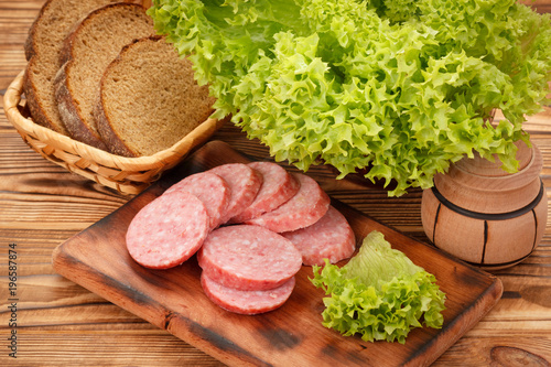 фотографія Sliced smoked pork sausage on cutting board