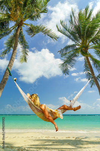 Woman relaxing on a hammock at the tropical beach resort