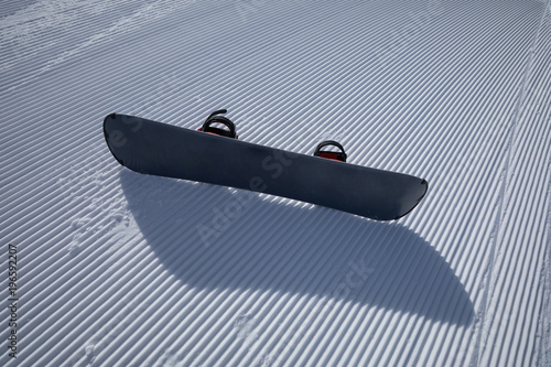 snowboard on ski piste in winter mountain slope