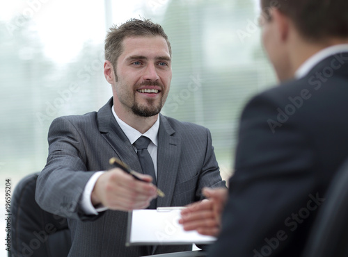 closeup.smiling businessman signing a lucrative contract.the business concept.
