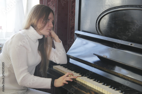 Canvas Print Young girl plays the piano - depressive concept