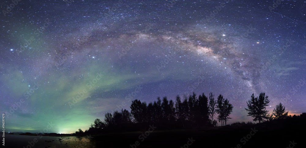 Stitched Panorama milky way galaxy during cloudy dark sky. image contain soft focus, blur and noise due to long expose and high iso.