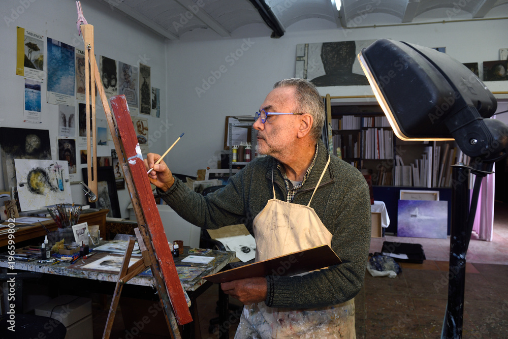 Painter artist painting a picture in the studio Painter artist painting a picture in the studio