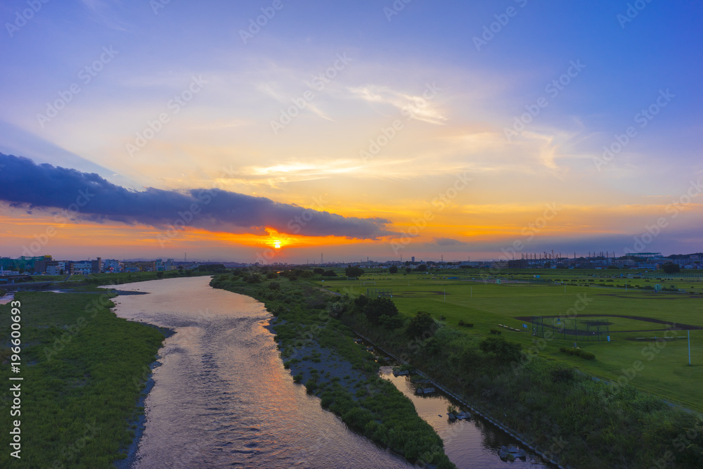 地平線に沈む太陽　多摩川河川敷夕景