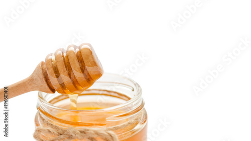 jar with honey and honey spoon on it. Isolated on white background. copy space, template.