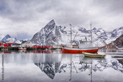 Beautiful winter landscape of harbor with fishing boat and traditional Norwegian rorbus