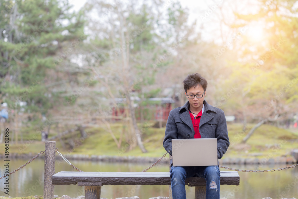 Fototapeta premium Happy Business Asian Man working with labtop outdoor in park
