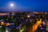 CITY AT NIGHT - Illumination, moonlit night and light wind farm on the horizon 
