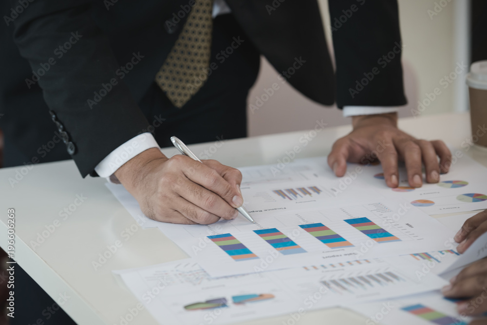Hand of Businessman working write with a pen on Data Charts,document at office desk. analyzing brainstorming, meeting concept. Hand of Businessman working write with a pen on Data Charts,document at office desk. analyzing brainstorming, meeting concept.