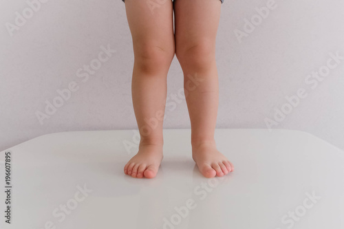 Tableau sur toile Low section of baby boy in diaper standing isolated on blue background