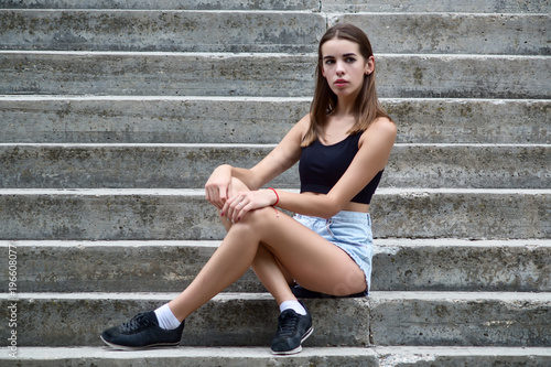 Young beautiful girl sitting on the stairs