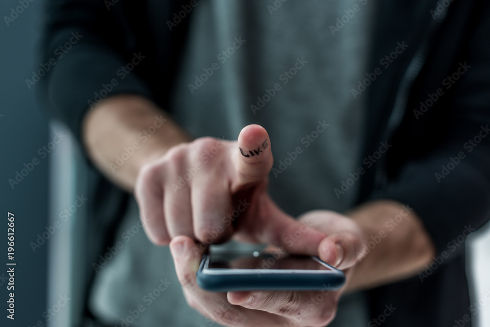 cropped shot of man touching smartphone screen with like sign on finger, phone addiction concept cropped shot of man touching smartphone screen with like sign on finger, phone addiction concept