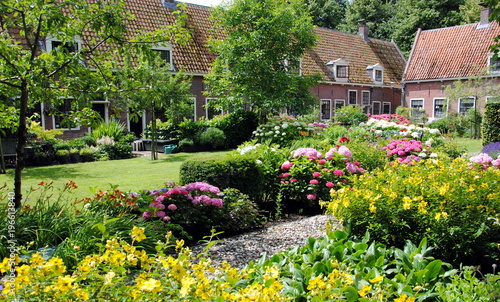 Canvas-taulu Row of cottages in a big flower garden in Edam, the Netherlands