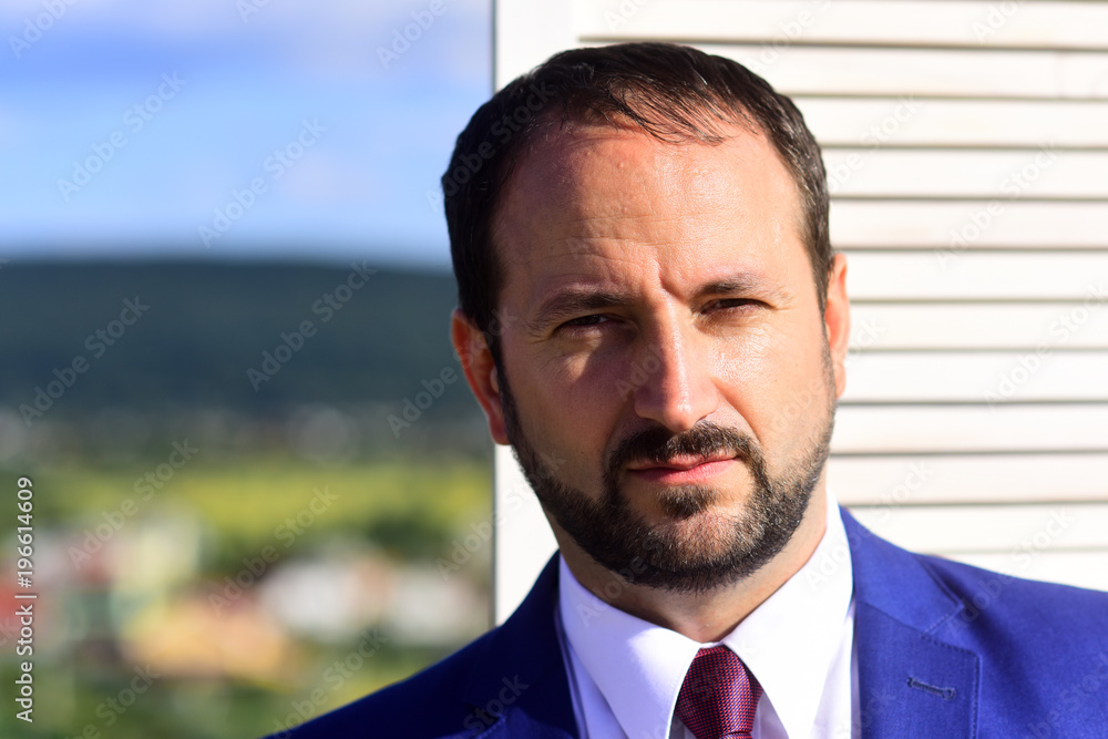 Businessman wears smart suit and tie on wooden wall Businessman wears smart suit and tie on wooden wall