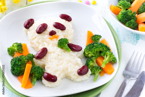 Fun food for kids - cute panda bear made of rice and red beans served with carrots and broccoli. Overhead view