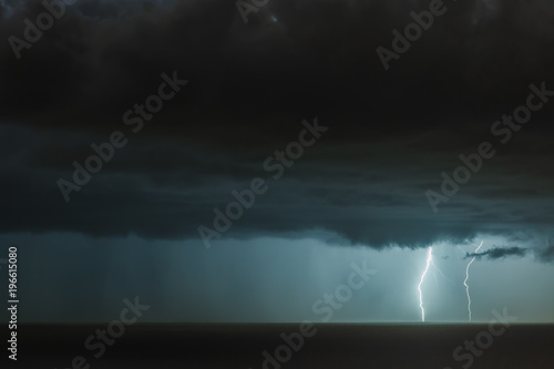 lightning bolts reflection over the sea. taken during a thunderstorm over the ocean with clouds in the background