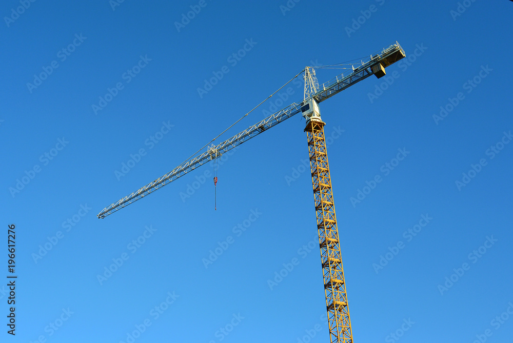 Industrial construction crane against blue sky in the background business real estate or architecture development concept