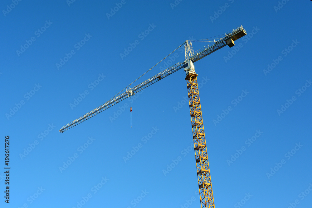 Industrial construction crane against blue sky in the background business real estate or architecture development concept Industrial construction crane against blue sky in the background business real estate or architecture development concept