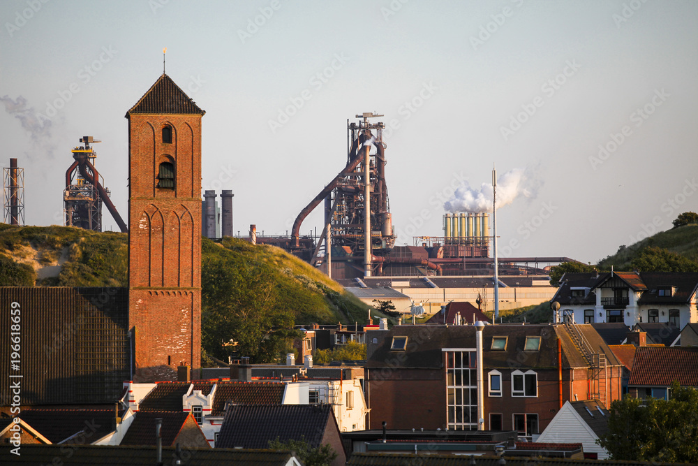 Wijk aan zee city church tower and the industrial park in the background	