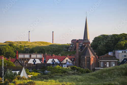 Wijk aan zee city church tower and the industrial park in the background	