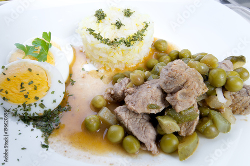 Delicious dinner beef Stroganov with peas and sterilized cucumber photo