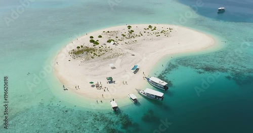 Aerial Footage of Small Sandy Island with People Resting, Walking and Swimming. Boat Cruise With Gorgeous Location, White Sand, Aquamarine Water and Coral Reef. Shot on RED Epic 4K UHD Camera.